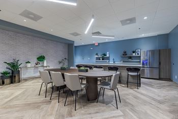 A conference room with a table and chairs and a kitchen